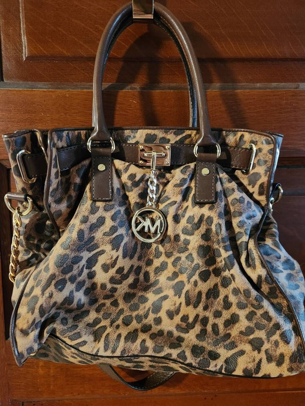 Michael Kors satchel featuring bold leopard-print exterior. Dark brown eather tr